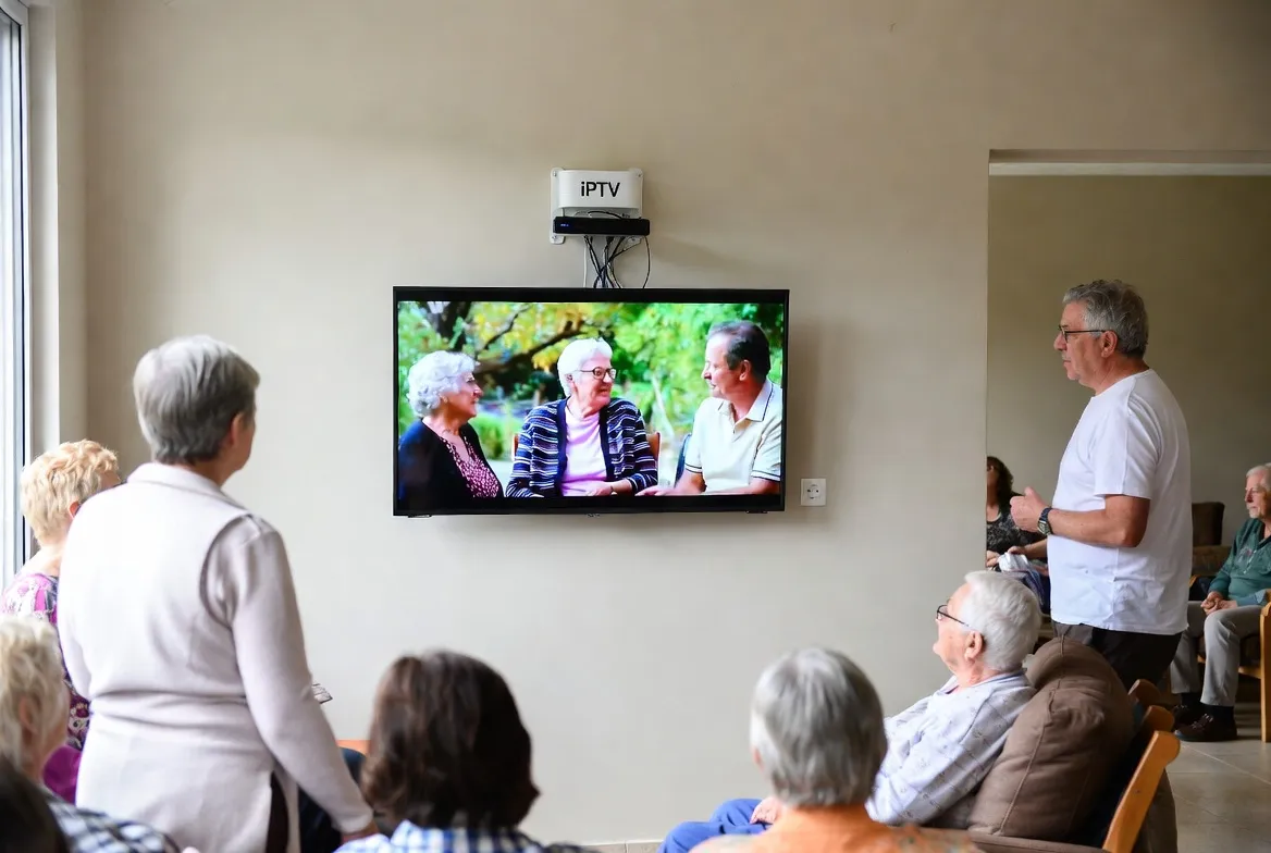 Elderly residents watching IPTV together in a care home lounge