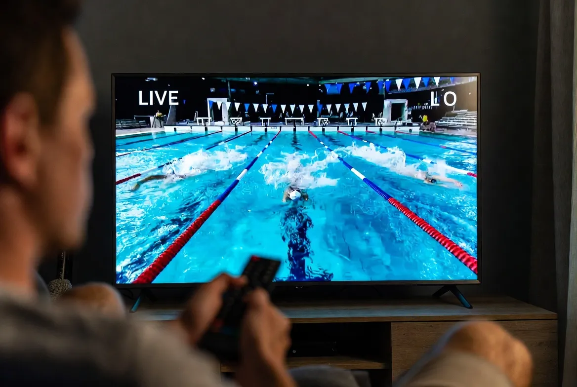 Viewer watching a live swimming event on TV via IPTV